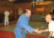 George shaking hands with his technical instructor Sensei Rejean after receiving his Brown belt